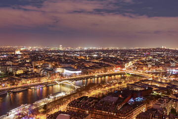 A breathtaking panoramic view from the Eiffel Tower of evening Paris in the bright lights of illumination