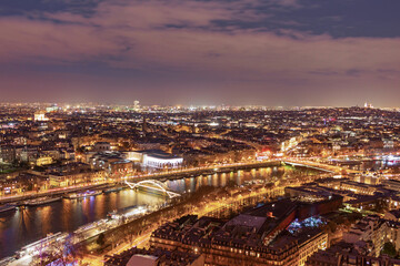 Fototapeta premium A breathtaking panoramic view from the Eiffel Tower of evening Paris in the bright lights of illumination
