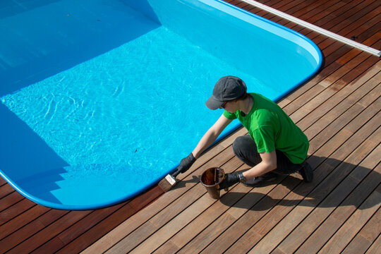 Seasonal restoration of wooden deck around the swimming pool, decking oil application