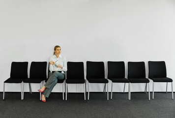 woman business chair sitting waiting businesswoman candidate recruitment office businessperson job young interview line employee career row hall colleague