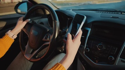 Hands of unrecognizable woman driver using mobile phone while driving car, distracted driving, don't text and drive