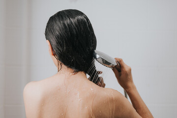 Woman washing hair with shampoo and shower in bathroom, Asian female body and hair care with foam...