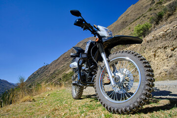 Detail of a motorcycle parked on the road during a trip to the interior of the country.