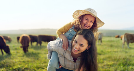 Family, farm and fun with a girl and mother playing on a grass meadow or field with cattle in the...