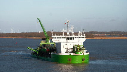 Elbe river, Germany - 01 20 2023: Belgian trailing suction hopper dredger with forward wheelhouse restricted in ability to maneuver during river maintenance © I am from Mykolayiv