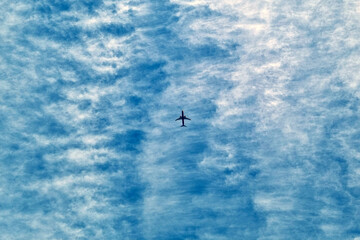 The plane flies in the sky. Blue sky. Travelling by plane.