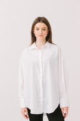 Photo of a pretty woman in a white shirt isolated on a white background. Shirt mockup.