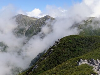 View of the Central Alps mountains hidden in fog at Mt. Sannosawa in Nagano Prefecture, Japan in July.