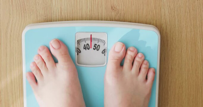 woman measure weight on scale