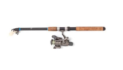 Assembled telescopic spinning rod with reel lies on white background..