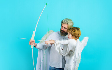Valentines day. Little cupid boy and father in angel costume with bow and arrow. Christmas angels.