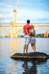 couple in love blonde girl and guy on the river bank