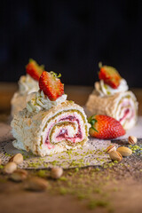 dessert meringue roll with strawberries close-up on the table