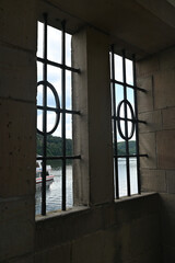 View through a barred window at the Staudam on the Eder lake with a ship