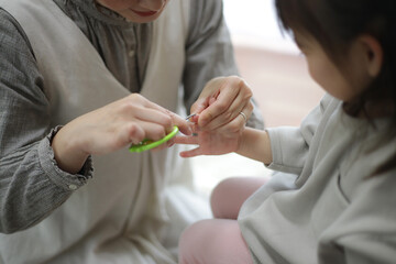 Obraz na płótnie Canvas 子供の爪を切る母親