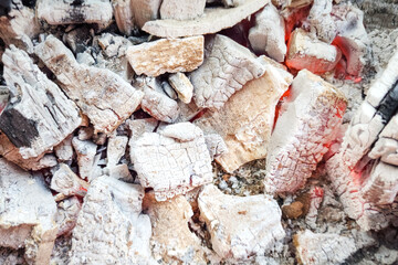 Burning firewood stack which is using for heating and cooking BBQ meal. Background and texture object, selective focus.