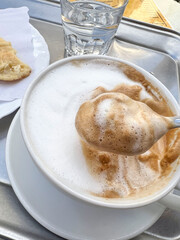 stirring cup of cappuccino coffee