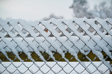 Chain-link fence in the snow, close-up photo