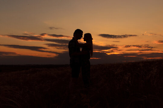 couple in love blonde girl in silhouette against an sunset