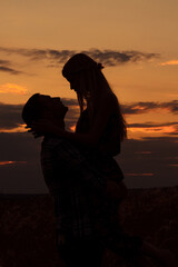 couple in love blonde girl in silhouette against an sunset