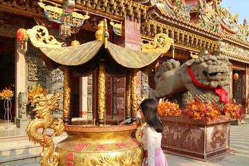 Female Visitor Placing Incense Sticks in the Burner of Chinese Buddhist Temple