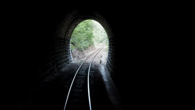 Train enter narrow tunnel on railway track seen from train driver perspective POV