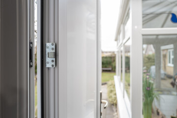 Shallow focus of a new, high security side door installed into a garage. The back garden and...