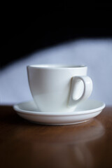 White cup hot drinking with steam on pine wooden table

