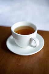 White cup hot drinking with steam on pine wooden table
