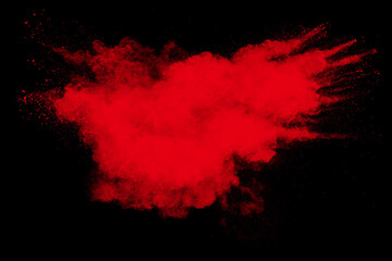 Red powder explosion cloud on black background. Freeze motion of red color dust  particle splashing.