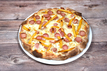 talian Pizza whit wurstel and French potatoes in a plate isolated on wooden background