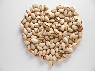 Valentines day love heart made from pistachio nuts in shells on white background