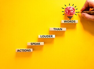 Actions speak louder words symbol. Concept words Actions speak louder than words on wooden blocks....