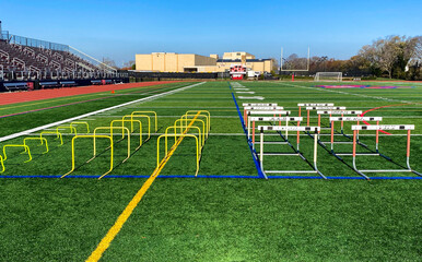 Hurdles set up for stength and agility practice on a turf athletic field
