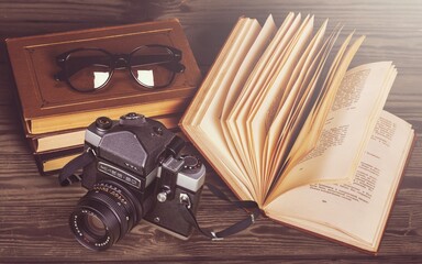 Old fashioned camera on bookshelf with retro books
