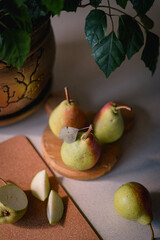 ripe pears on wooden plate on kitchen table