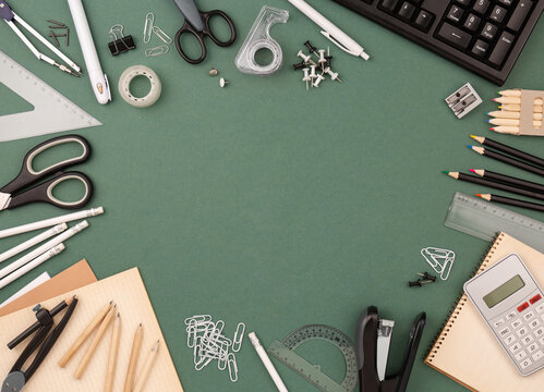 stationery items around of image on green background. Back to school background, banner with copy space. Student's or engineer's supplies. Office objects on dark green background. Calculator, keyboard