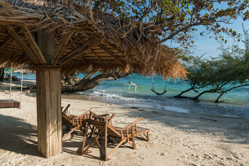 Wood deck chairs under parasol by blue sea, Ko Man Klang, Rayong