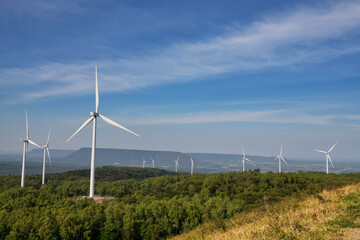 Hill and turbine windmill field against blue sky and white cloud