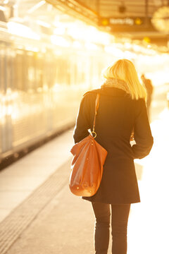 Woman in sunset on train station platform
