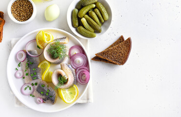 Salted herring with onion and lemon on plate