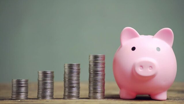 4K. Save money and account banking for finance concept, Hand with coin and piggy bank on blurred background