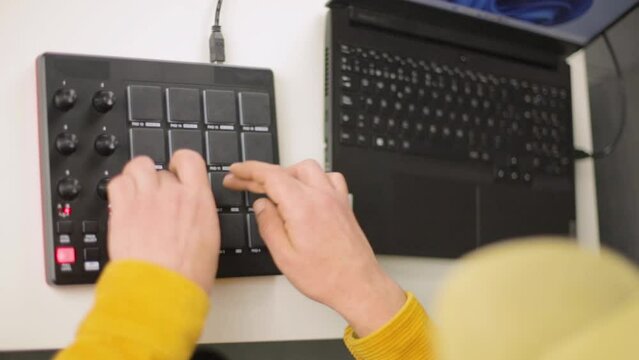 The hands of a mixed race man making beats on his MPD MIDI controller