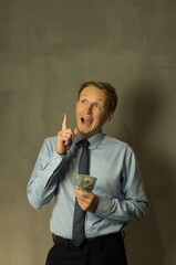 a man with money raised his finger up, came up with an idea how to make money, vertical shot