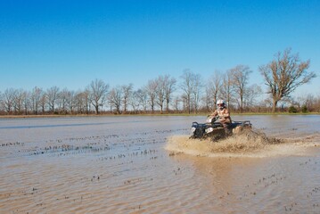 An ATV in a muddy rice field 