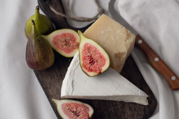 cheese and figs on a wooden board