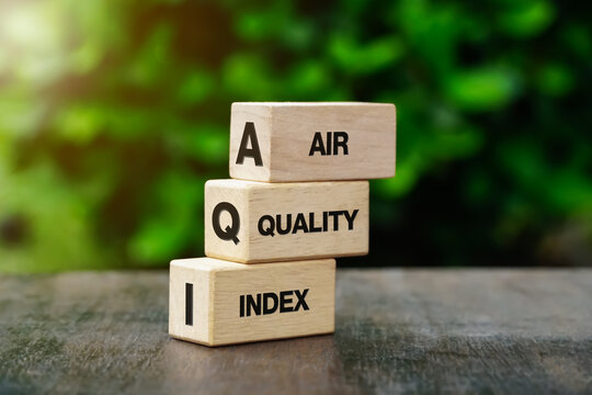 AQI Abbreviation of air quality index text on wooden cubes on nature background. 