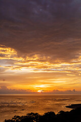Fototapeta premium Orange and purple sunset reflection on ocean