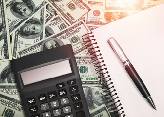 Office calculator and money bills on the desk, economics concept.