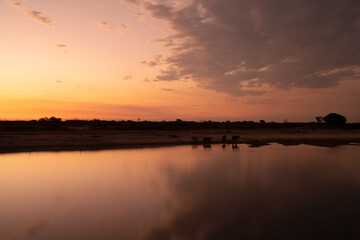 Long exposure shot. Panorama view of the desert and river at sunset. Beautiful reflection of the sky in the water surface. 